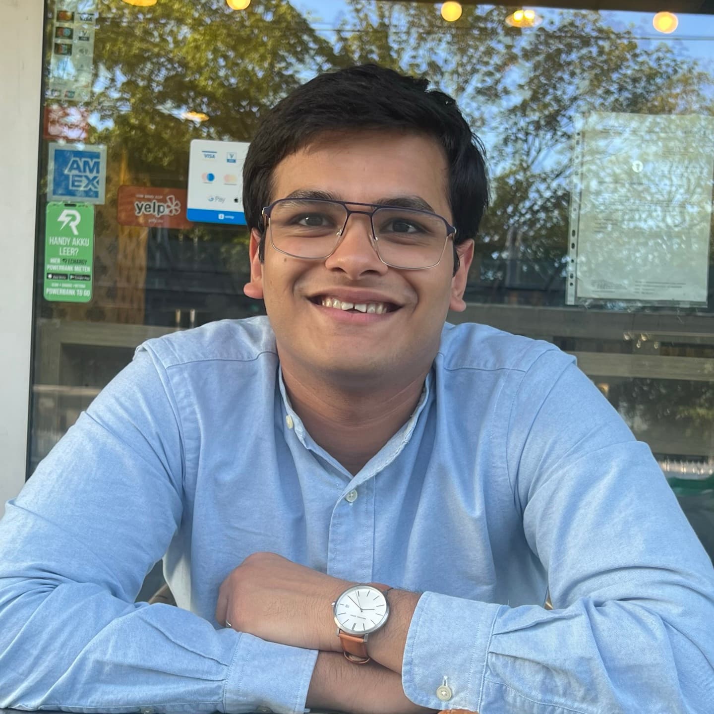 Eklavya smiling at a cafe window table